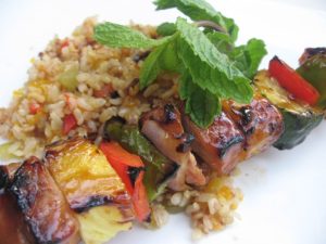 terriyaki pork kabobs plated with rice and mint garnish from the Kitchen Project