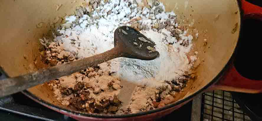 Cooking flour with bacon fat and onions for one minute until well-blended and bubbling in the pot