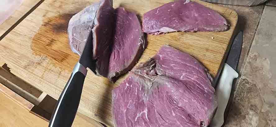 Slicing a beef round with a knife