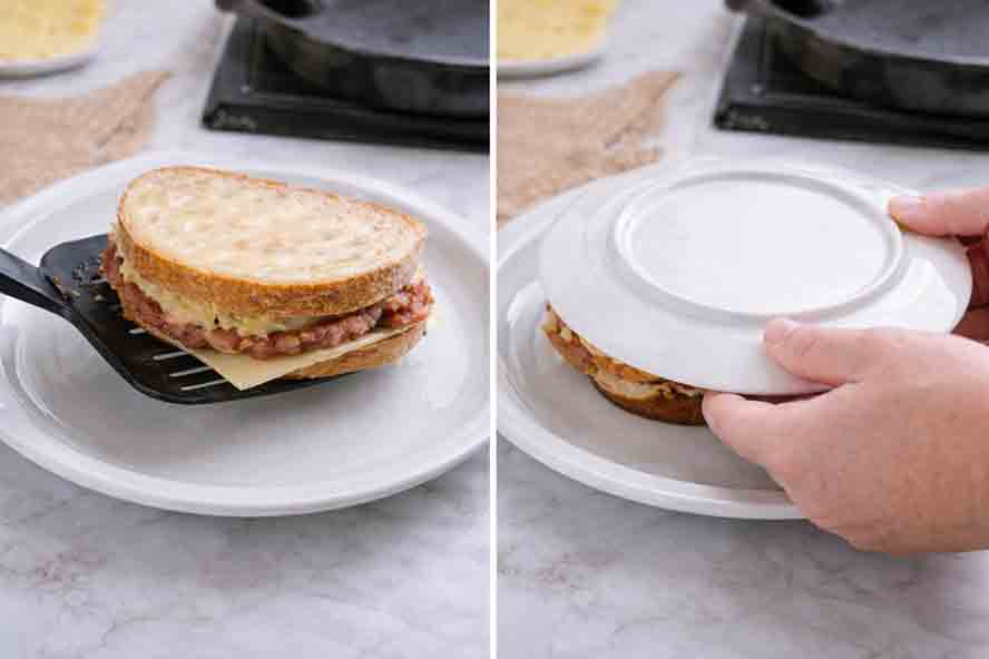 flip-reuben Using a black spatula to lift a grilled ,Placing a second white plate upside down over a Reuben sandwich to flip it safely in the pan."Reuben sandwich onto a white plate for flipping." Placing a second white plate upside down over a Reuben sandwich to flip it safely in the pan."