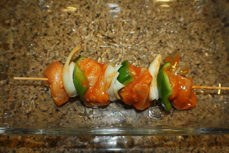 chicken-schaschlik-assembling-skewers.jpg threading marinated chicken, onions, and peppers onto skewers