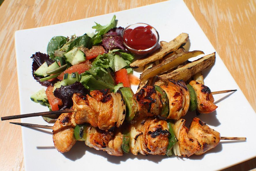 grilled chicken schaschlik skewers served with fries and fresh salad
