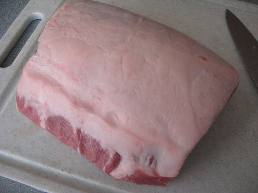 whole pork loin on cutting board ready to be trimmed for schnitzel