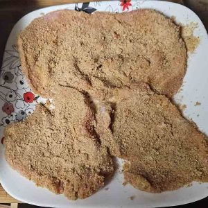 breaded pork schnitzel fully coated with breadcrumbs before frying