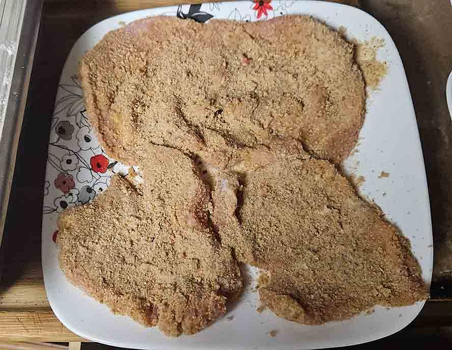 schnitzel-breading-hero breaded pork schnitzel fully coated with breadcrumbs before frying