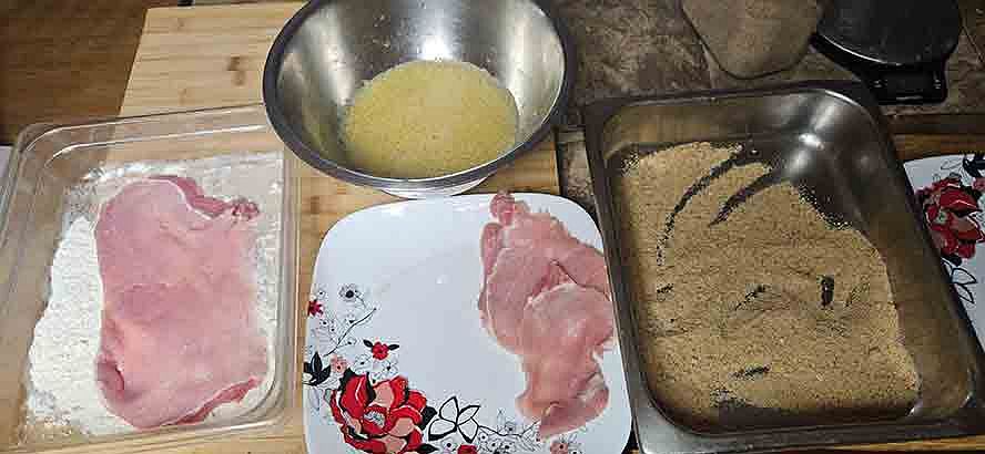 flour-step1-breading floured schnitzel dipped into egg wash for breading