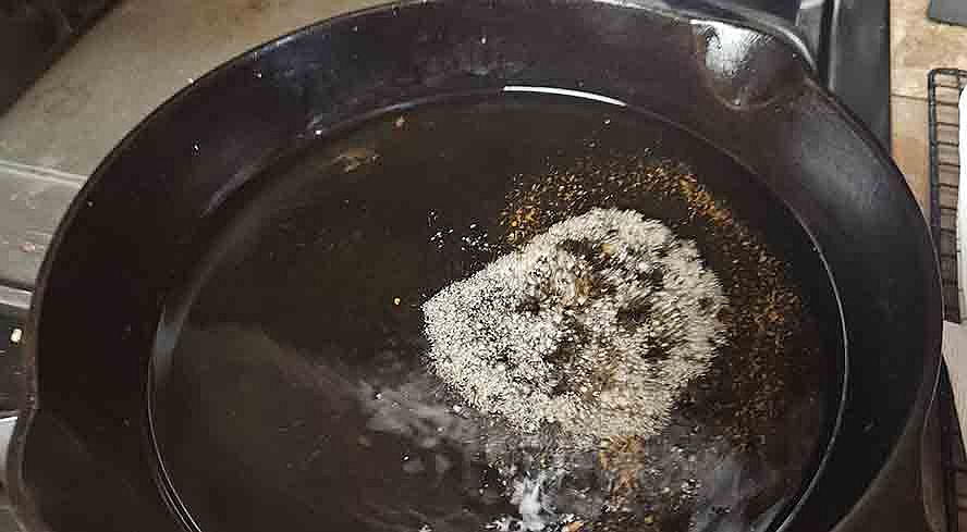 testing hot oil with breadcrumbs before frying schnitzel