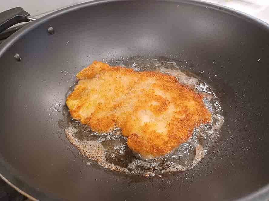 schnitzel-breading-9 turning schnitzel in pan to cook evenly on both sides