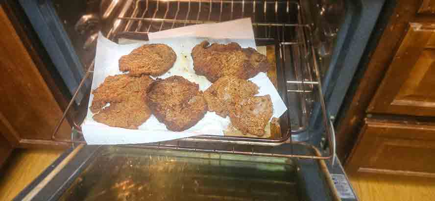 Schnitzels draining on towels.