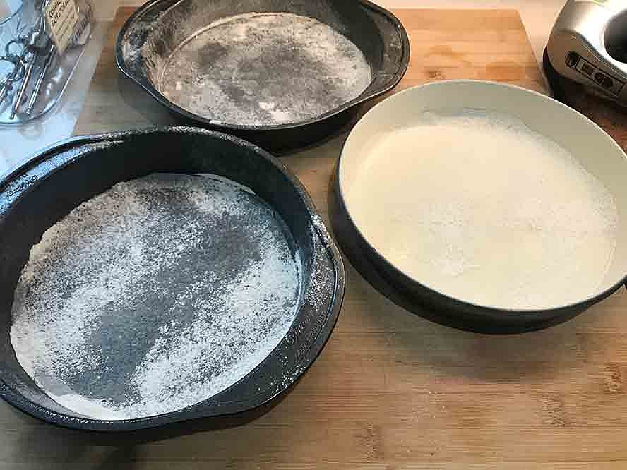 Three round cake pans prepared with flour for baking the German chocolate cake.
